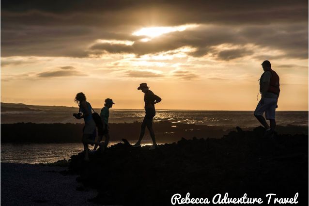 Travelers in Punta Carola beach during the sunset