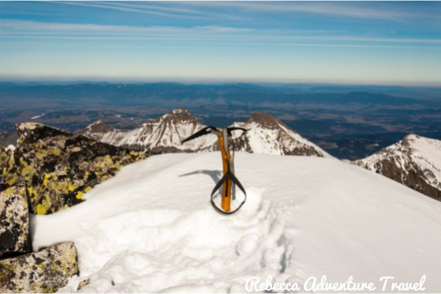 Climbing axe on the top of a snowy mountain