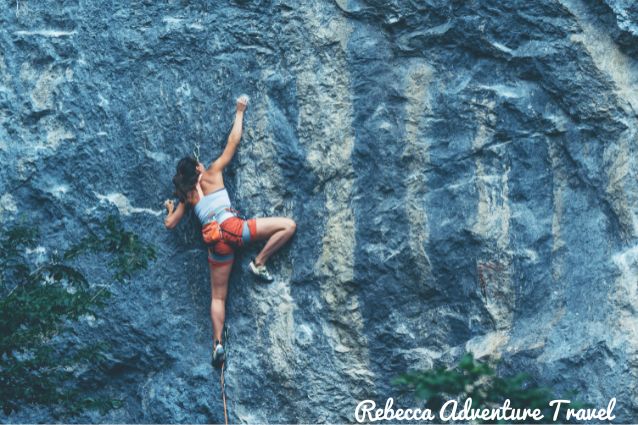 Girl climbing up a rock wall